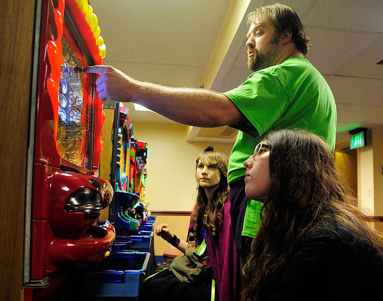 Pachinko Fever owner Jared Presler shows Westphalia sisters Michelle, right, and Marlene Kliethermes how to play pachinko during Cosplacon 2015 at the Capitol Plaza Hotel. Pachinko is a popular Japanese arcade game similar to a pinball machine but stands vertical and doesn't use flippers. 

