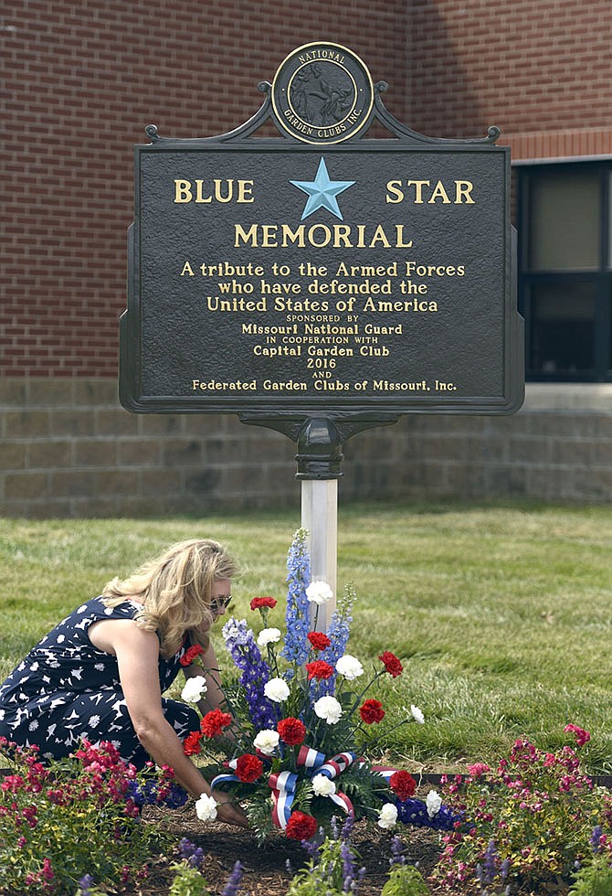 Jeannine Brickey presents a tribute of flowers at the Blue Star memorial marker dedication Tuesday.