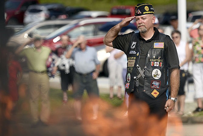 Vince Rost salutes burning retired American flags at the Flag Day ceremony in 2016 at American Legion Post 5. "It's an honor and respect that we show our country and service people," he said.