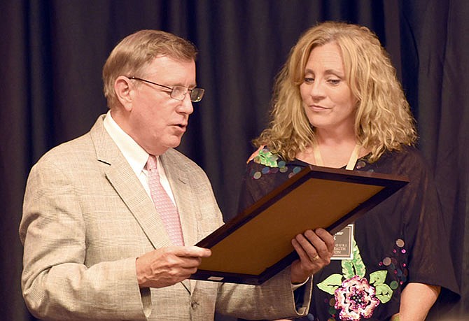 From left, president of the board of directors for Missouri Mental Health Foundation Mike Keller gives an award to Heather Gieck at the foundation's banquet Tuesday at Capitol Plaza Hotel. Gieck is honored for opening her home to women facing substance abuse issues in Jefferson City.
