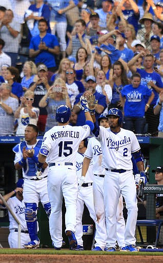Kansas City Royals' Whit Merrifield (15) is congratulated by teammate Alcides Escobar (2) after his solo home run off Cleveland Indians starting pitcher Josh Tomlin during the third inning of a baseball game at Kauffman Stadium in Kansas City, Mo., Tuesday, June 14, 2016. 