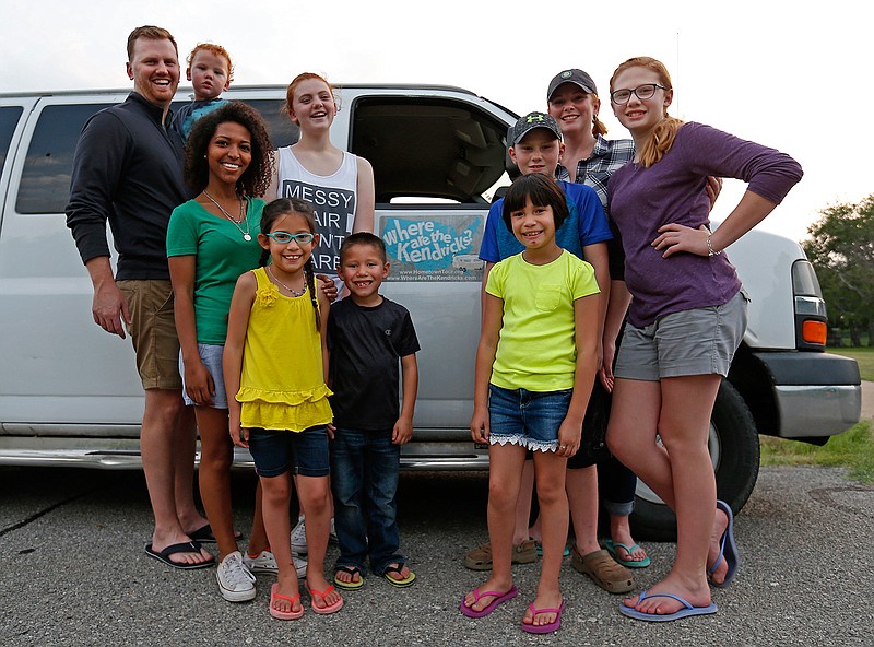 Bruce and Denise Kendrick pose for a photograph with their eight children next to a van after they arrived from a trip in Frisco, Texas, on May 25, 2016. They traveled across the nation in a camper trailer as part of missionaries with Embrace to support foster and adopted children and families. From youngest: Chapel, 2, Chuy, 7, Ellen, 8, Mattie, 9, Shepherd, 10, Kate, 12, Macy, 13, and Genet, 20. 