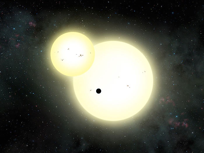 This undated artist rendering provided by San Diego State University shows a planet, dubbed Kepler 1647 B, the small black dot at center, as it orbits two suns, designated Kepler-1647 A, the larger star, and Kepler 1647 B, outside our solar system. 
