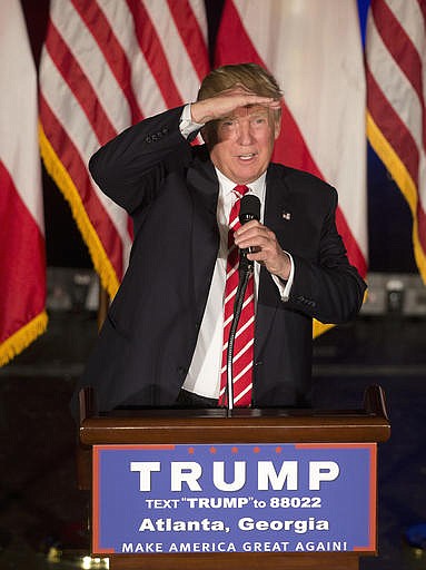 Republican presidential candidate Donald Trump shields his eyes as he speaks during a rally at the Fox Theater, Wednesday, June 15, 2016, in Atlanta. 