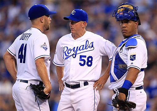Kansas City Royals pitching coach Dave Eiland (58) and catcher Salvador Perez, right, talk with starting pitcher Danny Duffy (41) during the fourth inning of a baseball game against the Detroit Tigers at Kauffman Stadium in Kansas City, Mo., Thursday, June 16, 2016.