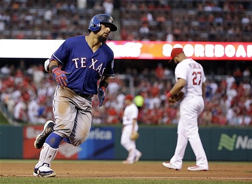 Texas Rangers' Rougned Odor, left, rounds the bases past St. Louis Cardinals third baseman Jhonny Peralta after hitting a solo home run during the fifth inning of a baseball game Friday, June 17, 2016, in St. Louis.