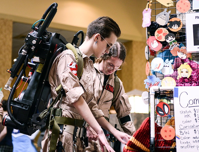 Raegan Richards browses through a vendor's stand in her customized replica ghostbuster costume during the fourth annual Cosplacon, taking place in Jefferson City at Capitol Plaza Hotel.
