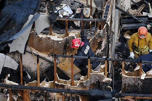 Los Angeles Fire Department arson investigators examine the burned-out ruins of an abandoned office building in the Westlake district just west of downtown Los Angeles Tuesday, June 14, 2016.