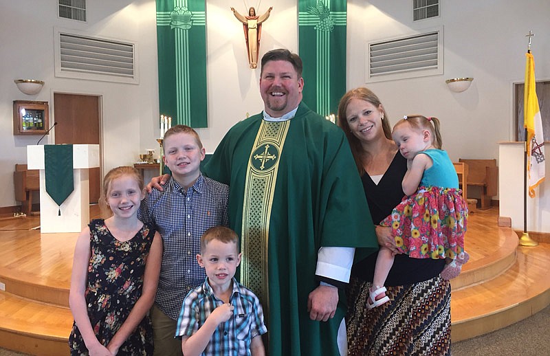 The Rev. Stephen Jones, priest at St. Michael's Catholic Church, stands with his family — wife, Kerri, and children, Colman, 13; Dwyn, 10; Fisher, 6; and Serafina, 2.