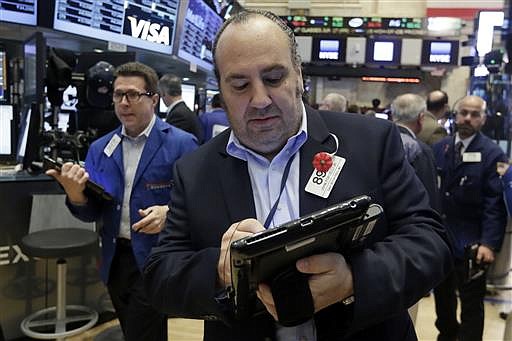 Trader John Porcelli, center, works on the floor of the New York Stock Exchange, Friday, June 17, 2016. 