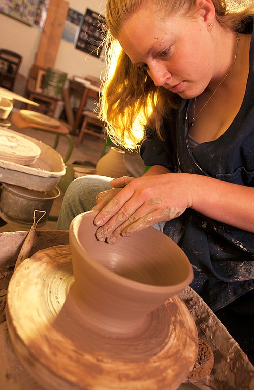 A student tries her hand at the pottery wheel.