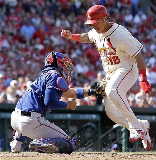 St. Louis Cardinals' Kolten Wong, right, is tagged out at home by Texas Rangers catcher Robinson Chirinos during the fifth inning of a baseball game Saturday, June 18, 2016, in St. Louis.