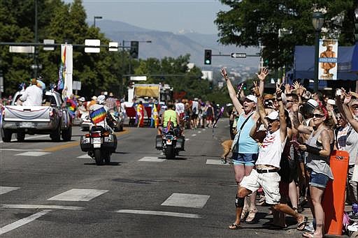 A crowd cheers for participants in the gay pride parade in Denver, Sunday June 19, 2016.