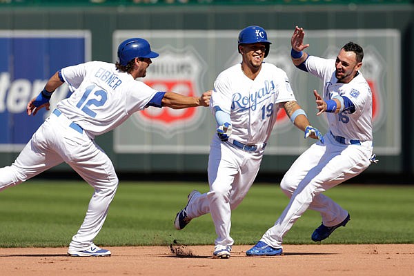 Cheslor Cuthbert (center) of the Royals is chased down by teammates Brett Eibner and Paulo Orlando as they celebrate his game-winning hit in the 13th inning of Sunday afternoon's game against the Tigers at Kauffman Stadium.