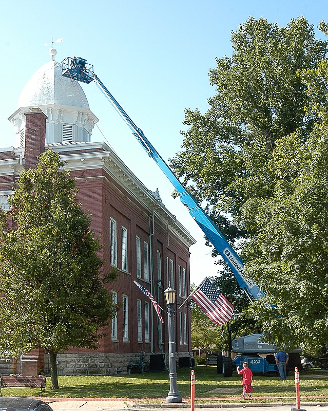 The top of the dome is cleaned Friday, June 17, by Delbert Brandes and Mike Meier, employees of Septagon Construction, working from a platform on a lift. Randi Turley is on the ground for supervision and to ensure safety during the project.