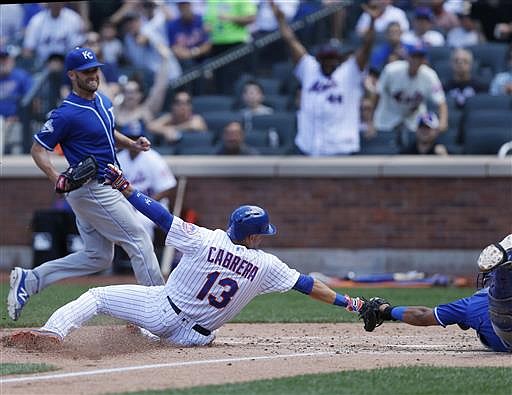 Kansas City Royals starting pitcher Danny Duffy, upper left, watches as New York Mets' Asdrubal Cabrera (13) scores past a diving Royals catcher Salvador Perez during the fifth inning of an interleague baseball game Wednesday, June 22, 2016, in New York.