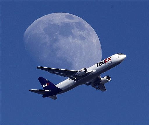 In this Sunday, July 26, 2015, file photo, a FedEx cargo airplane passes over Whittier, Calif., on its way to Los Angeles International Airport.
