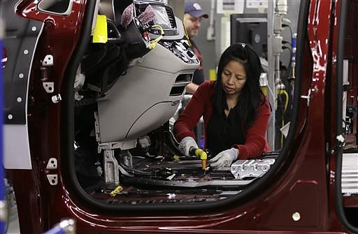 In this Friday, May 6, 2016, file photo, Tina Nguyen works on a 2017 Chrysler Pacifica on an assembly line at the Windsor Assembly Plant, in Windsor, Ontario.