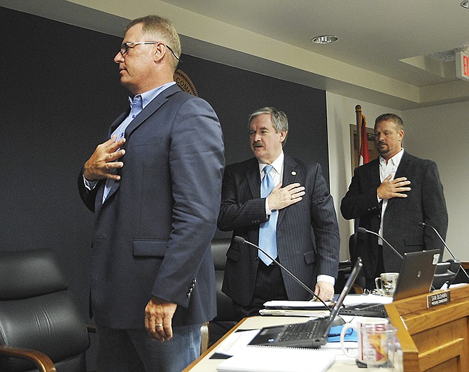 From left, Cole County Commissioners Kris Scheperle, Sam Bushman and Jeff Hoelscher, turn to the United States flag to pledge allegience during a commission meeting on June 21, 2016.