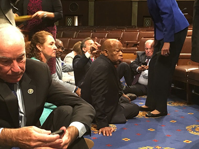 This photo provided by Rep. John Yarmuth, D-Ky., shows Democrat members of Congress, including Rep. John Lewis, D-Ga., center, and Rep. Joe Courtney, D-Conn., left, participating Wednesday in a sit-down protest seeking a vote on gun control measures on the floor of the House on Capitol Hill in Washington. 