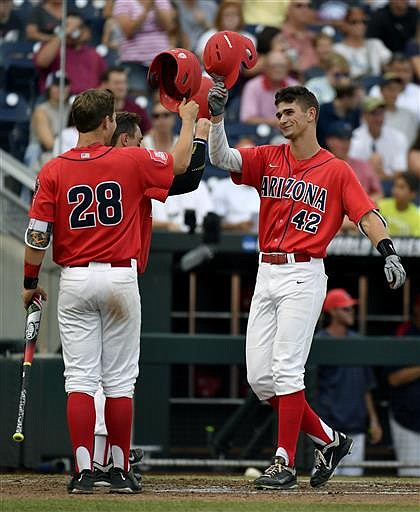 Arizona's Jared Oliva, right, is congratulated by teammate Kyle Lewis after hitting a two-run home run during the third inning of an NCAA College World Series baseball game against UC Santa Barbara, Wednesday, June 22, 2016, in Omaha, Neb.