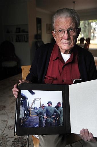 In a Nov. 10, 2015 photo, helicopter pilot Lt. Col. Charles Kettles, (Ret) 85, shows a photograph taken of him and his helicopter on May 15, 1967, the day he rescued his crew of three plus nine ground troops in Vietnam. The White House announced Tuesday, June 21, 2016, some five decades after he led a platoon credited with rescuing dozens of soldiers pinned down by enemy fire, Kettles will be awarded the Medal of Honor, the nation's highest military honor for valor. (Brandy Baker/The Detroit News via AP)