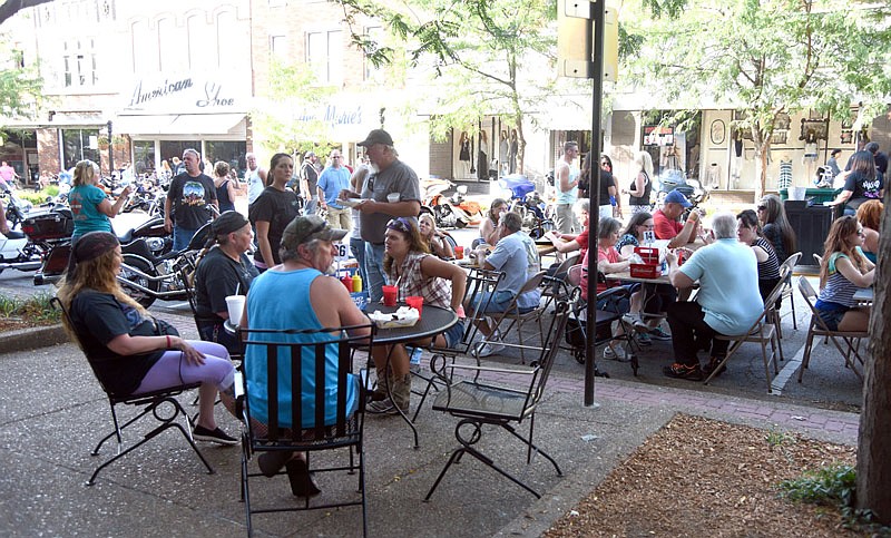 People sit and eat in front of Spectators on High Street for Thursday Night Live on June 23, 2016.