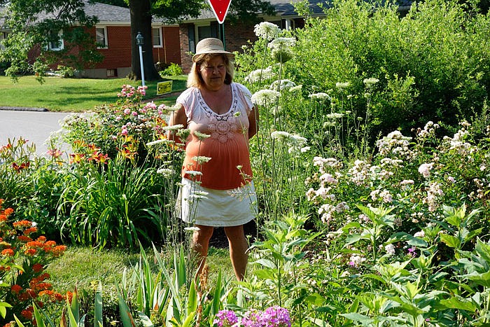 Fran Lake, a member of the Fulton Garden Club, looks over Joan Sampson's garden during the annual garden tour Thursday.