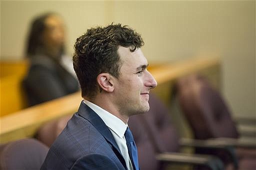 In this May 5, 2016 file photo, former Cleveland Browns NFL quarterback Johnny Manziel sits while his defense attorneys confer with the prosecution during his initial hearing in Dallas. 