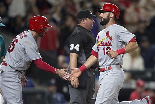 St. Louis Cardinals' Greg Garcia, left, congratulates teammate Matt Carpenter after Carpenter and Garcia scored on a bases-loaded single by Matt Holliday during the eighth inning of a baseball game against the Seattle Mariners on Friday, June 24, 2016, in Seattle.