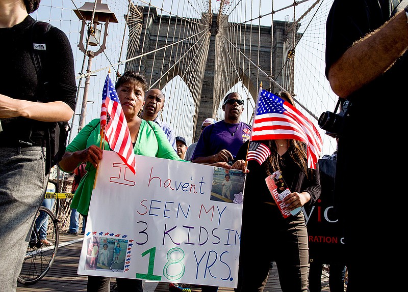 In this Oct. 5, 2013, file photo, Martha Gualotuna of New York, center left, walks across the Brooklyn Bridge during a march and rally highlighting immigration reform, in New York. Gualotuna is one of the four million immigrants who would have benefited from a program that was blocked on Thursday, June 23, 2016, by a decision of the Supreme Court. 