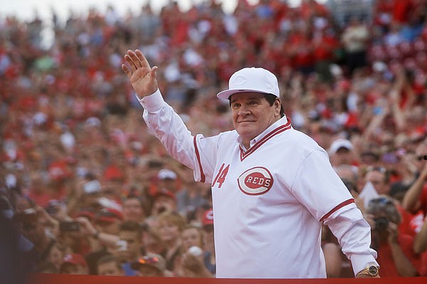 Former Red Pete Rose waves to the crowd as he is introduced on the field during a ceremony to honor the 1976 World Series champions team before the Reds' game against the Padres on Friday in Cincinnati.