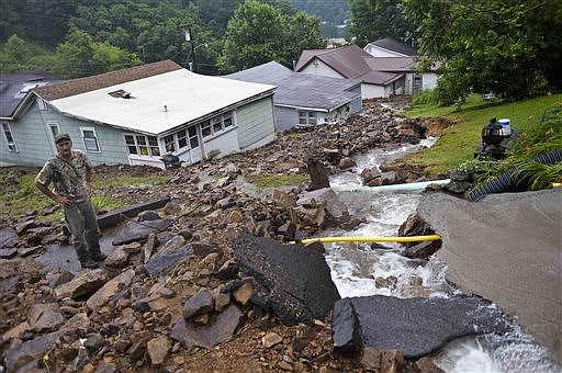 Rob Morissin stands among the aftermath of a rockslide caused by severe flooding that poured into a property owned by his family since the 1930's in Richwood, W.Va. on Friday June 24, 2016. (Christian Tyler Randolph/Charleston Gazette-Mail via AP)