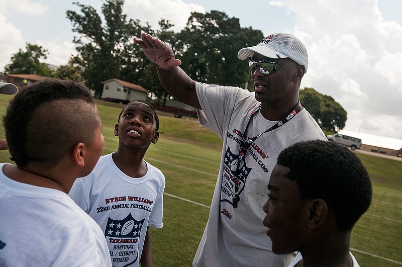 Former NFL player Byron Williams, right, speaks to participants between drills during his 22nd annual Byron Williams Football Camp about the importance of good nutrition and exercise Saturday, June 25, 2016 at Texas Middle School in Texarkana, Texas.