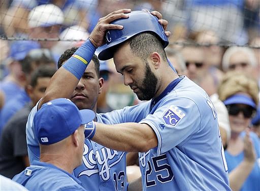 Kansas City Royals Salvador Perez. left, removes Kendrys Morales' helmet after Morales' home run in the fourth inning of a baseball game against the Houston Astros at Kauffman Stadium in Kansas City, Mo., Sunday, June 26, 2016.