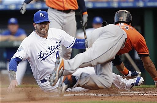 Kansas City Royals pitcher Peter Moylan, left, tags out Houston Astros Carlos Gomez, right, after he attempted to score from third base on a wild pitch in the third inning of a baseball game at Kauffman Stadium in Kansas City, Mo., Saturday, June 25, 2016. 