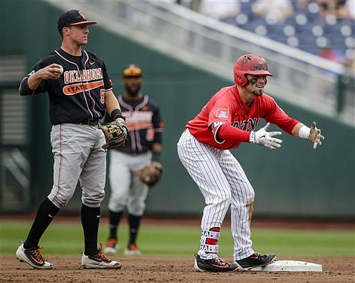 Arizona's Cody Ramer, right, reacts after hitting a double while standing in front of Oklahoma State shortstop Donnie Walton (5) during the first inning of an NCAA men's College World Series baseball game in Omaha, Neb., Saturday, June 25, 2016.