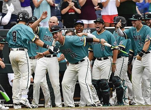 Coastal Carolina's Tyler Chadwick (8) is greeted at the dugout by teammates, including Seth Lancaster (26), after hitting a solo home run during the second inning of an NCAA men's College World Series baseball game against TCU in Omaha, Neb., Saturday, June 25, 2016.