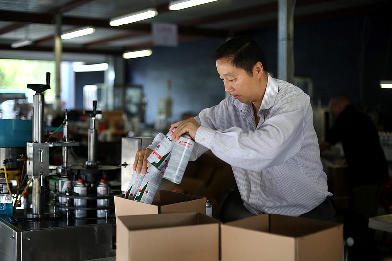 Jude Shao, CEO, fills orders of butane canisters, at American Energy Products Company, Friday, June 10, 2016, in Houston, Texas. American Energy manufactures butane canisters for Coleman and Sky Blue, their own brand name. Shao spent a decade in a Chinese prison, uncertain when he'd be let go, and then was barred from leaving Shanghai for five more years.