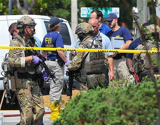 In this June 12, 2016 file photo, FBI, Orlando Police Department and personnel from the Orange County Sheriff's Office investigate the attack at the Pulse nightclub in Orlando, Fla. (Craig Rubadoux/Florida Today via AP, File)