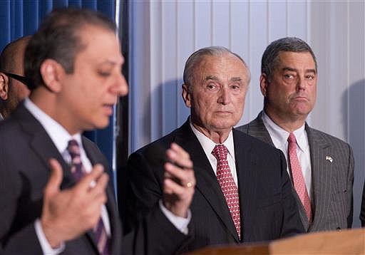 New York City Police Commissioner William Bratton, center, listens to U.S. Attorney Preet Bharara, left, announcing the arrest of four people in connection with New York City's ongoing corruption probe, Monday, June 20, 2016, in New York. Two high-ranking New York Police Department officials and a police sergeant who oversaw gun license applications were among the latest arrests in a case that has cast a cloud over the nation's largest municipal police force.