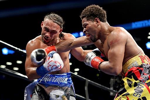 Keith Thurman absorbs a right hand from Shawn Porter during their WBA Welterweight title fight at the Barclays Center in Brooklyn borough of New York on Saturday, June 25, 2016. Thurman won via unanimous decision to retain his title.
