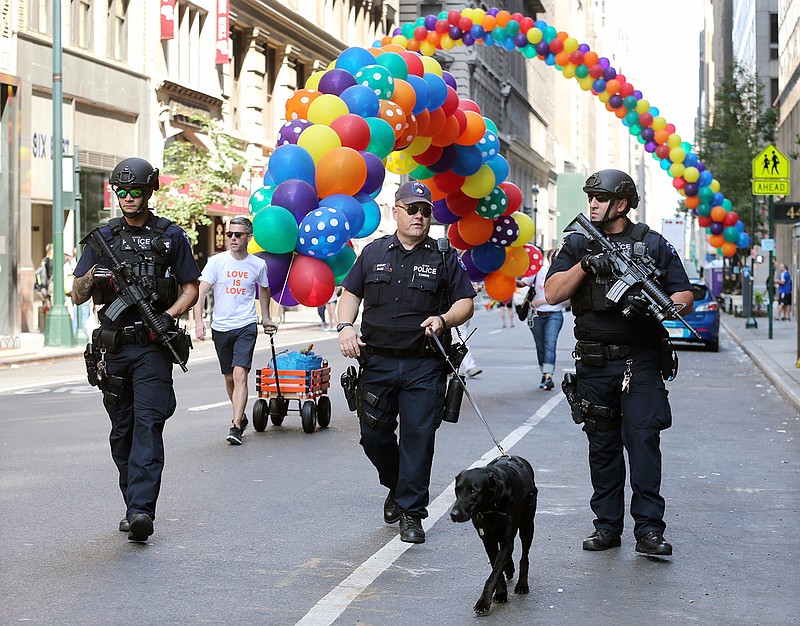 Heavily armed police officers walk along the street near the parade route of the New York City Pride Parade on Sunday, June 26, 2016, in New York City. A year after New York City's storied gay pride parade celebrated a high point with the legalization of gay marriage nationwide, the atmosphere this year couldn't be more different. Parades in New York and other major cities Sunday will feature increased security, anti-violence messages and tributes to those killed in this month's massacre at a gay nightclub in Florida.