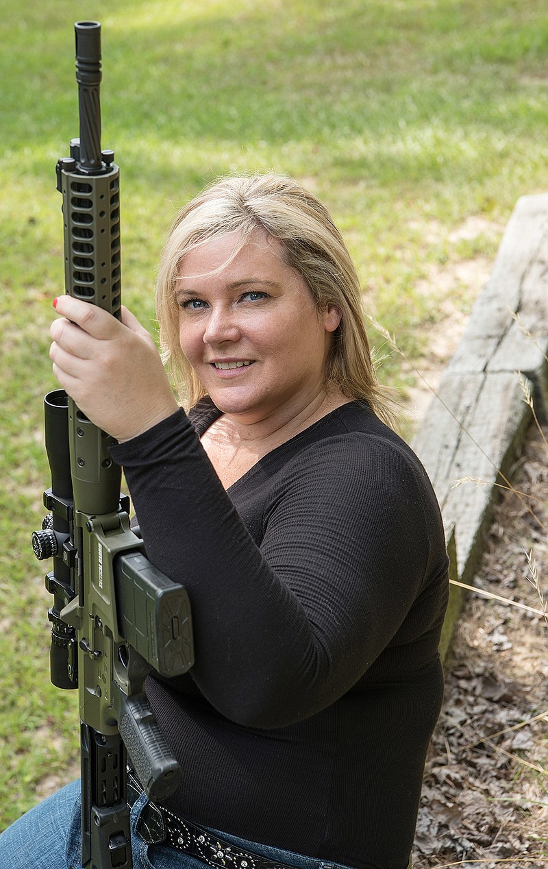 In this photo taken June 24, 2016, Dara Humphries, an NRA and Glock firearms instructor, poses for a portrait in Gainesville, Ga., holding an AR-platform rifle at a gun range. An estimated 8 million AR-style guns have been sold since they were first introduced to the public in the 1960s, and about half of them are owned by current or former members of the military or law enforcement, according to the National Shooting Sports Foundation, which represents gunmakers.