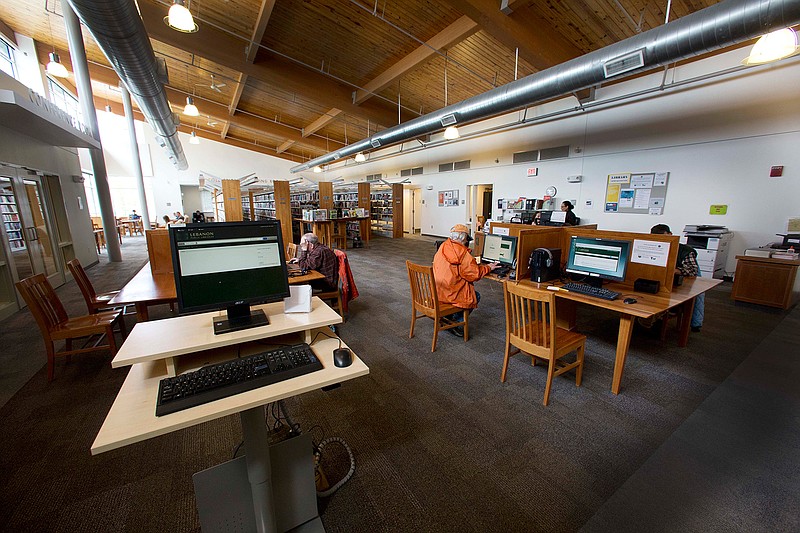 In this Thursday, May 19, 2016 photo, people at right sit at public computers at the Kilton Public Library in Lebanon, N.H. The library was chosen as a test site for the Library Freedom Project to use a software known as Tor, a secrecy software that largely prevents government surveillance. 