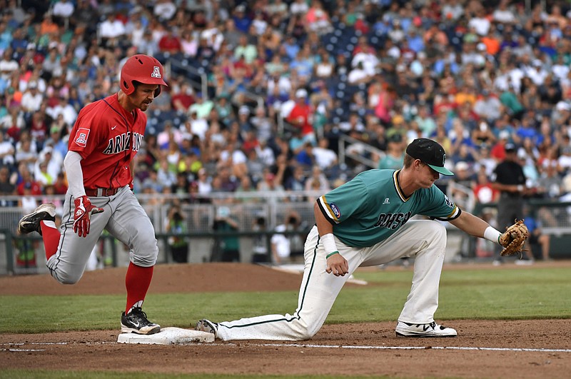 Coastal Carolina first baseman Kevin Woodall Jr., right, catches the throw for an out on Arizona's Louis Boyd during the fourth inning in Game 1 of the College World Series finals Monday in Omaha, Neb.