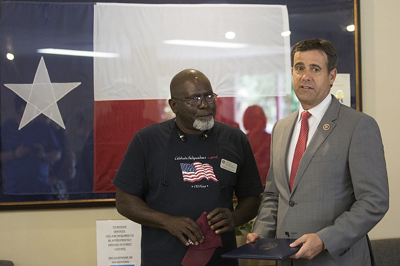 U.S. Rep. John Ratcliffe, R-Texas, recognizes the actions of Earnest Briggs, a bus driver with the TRAX program, with the Lone Star Award Monday afternoon during the meeting of the Ark-Tex Council of Governments in Texarkana, Texas. Briggs is credited with saving the life of Brenda McCoy, one of his regular riders. 