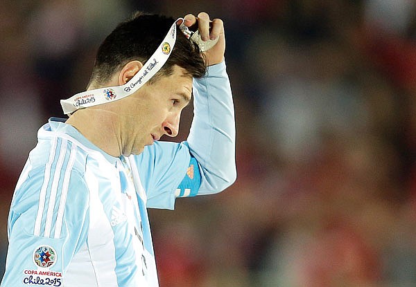 In this July 4, 2015, file photo, Argentina's Lionel Messi takes off the Copa America silver medal after the final game with Chile at the National Stadium in Santiago, Chile. Messi's shocking decision to stop playing for Argentina could further hurt his already tarnished legacy with his national team.