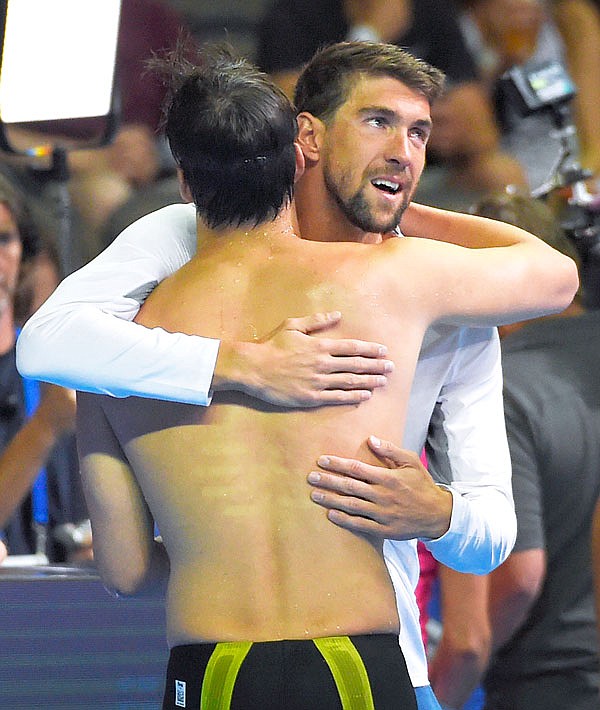 Jay Litherland gets a hug from Michael Phelps, right, after swimming in the men's 400-meter individual medley final Sunday at the U.S. Olympic swimming trials, Sunday in Omaha, Neb.