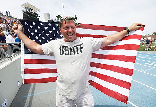 In this 2013 file photo, American shot putter Adam Nelson reacts to the crowd after being honored as the 2004 Olympic champion during a ceremony at the U.S. Championships in Des Moines, Iowa. He will attend the Olympic Trials starting Friday in Eugene, Ore.